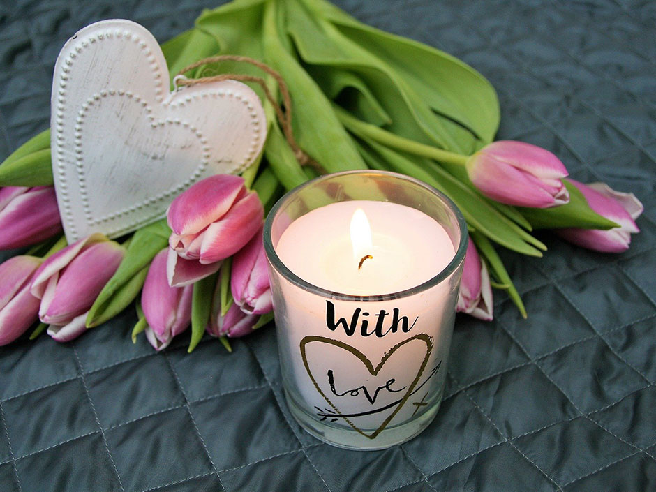 Eine Kerze mit Tulpen.